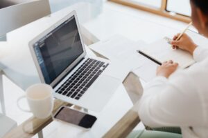 Small business owner writing website copy on a laptop at their desk